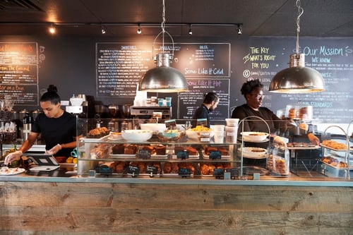 staff-working-behind-counter-in-busy-coffee-shop-2022-03-30-20-23-37-utc-1